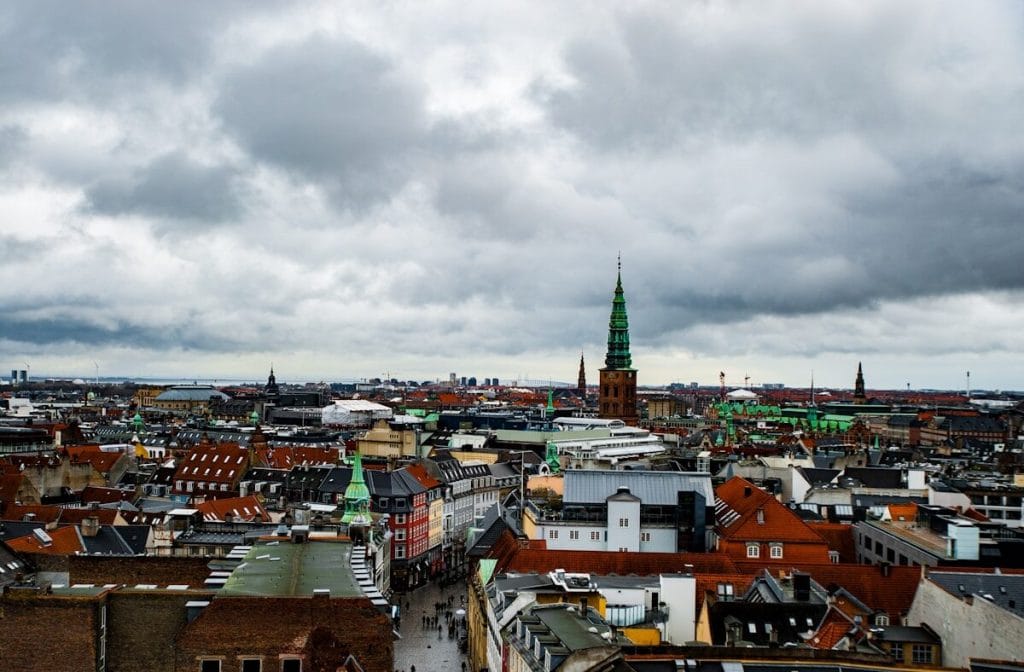 Panoramaudsigt over Københavns tage med Nikolaj Kirkes tårn under dramatisk skydække