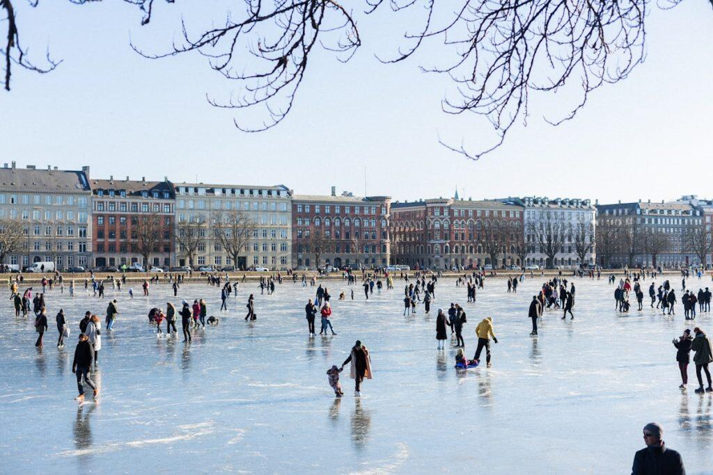 Mennesker på isen på de frosne Søer ved Nørrebro i København under klar vinterhimmel
