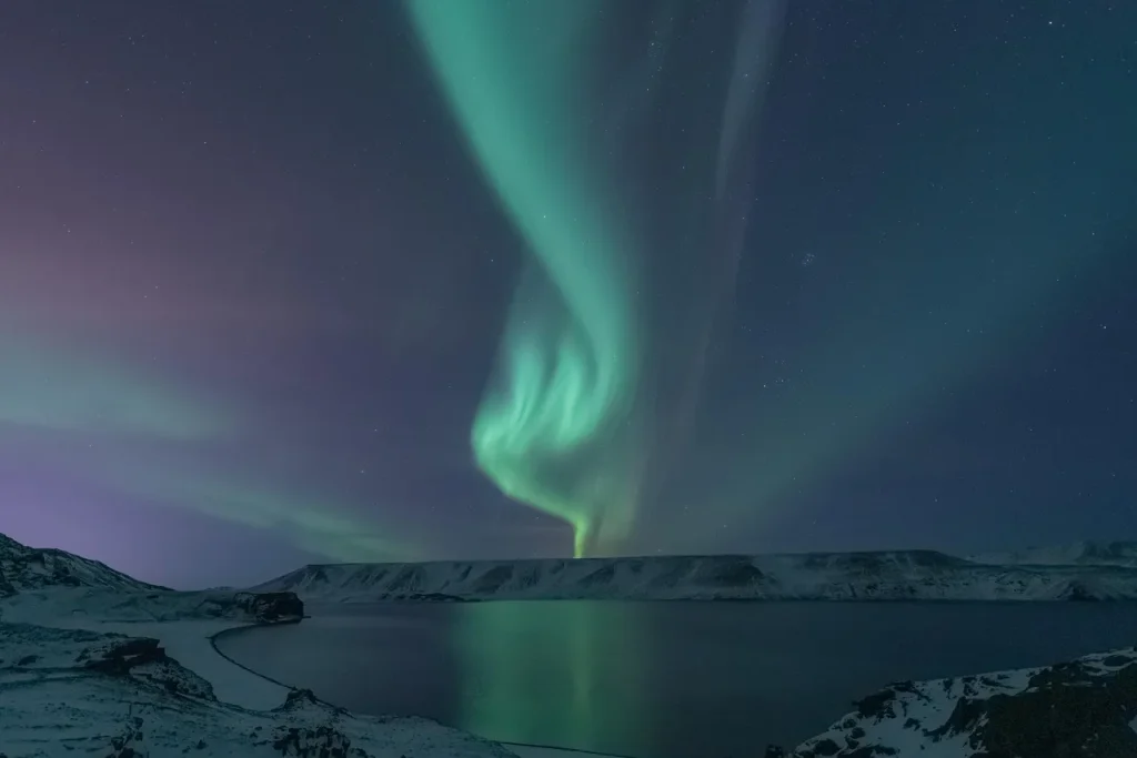 Nordlys over et snedækket landskab med sø i Skandinavien